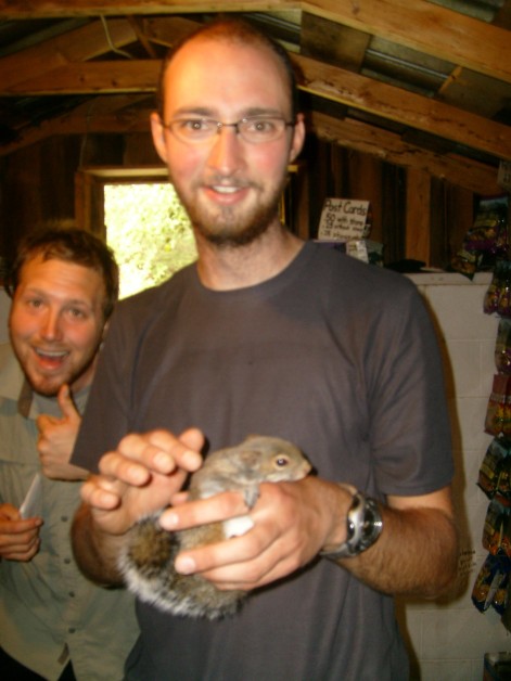 The Navigator (Martin) holding the Standing Bear's pet squirrel inside the supply hut. Plan B (Seth) approves of the situation.